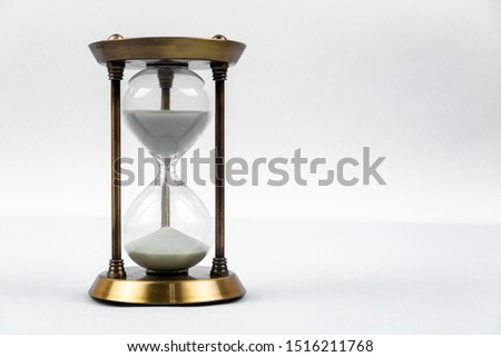 time concept with hourglass lying toned in warm black and white, retro style. Royalty-Free Stock Photo #1516211768