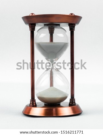 Sand clock time concept with hourglass lying toned in warm bronze, retro style, vertical orientation. Royalty-Free Stock Photo #1516211771