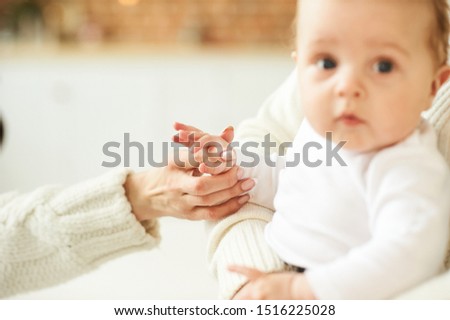 A beautiful young mother with a baby in a Christmas decorated room near the Christmas tree on a background of lights and music