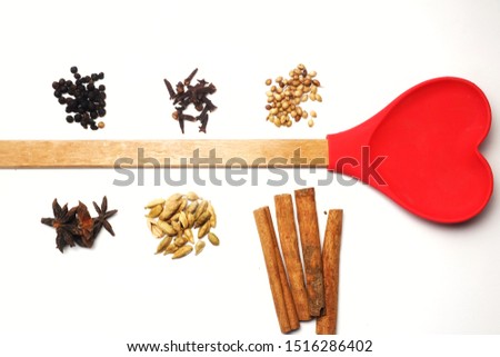 A picture of Asian herbs consist of pepper, clove, star anise, coriander, cardamom and cinnamon with love shape spatula.