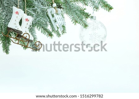 winter holiday concept decoration with christmas tree branch, decorative skates, sledges toys and transparent glass ball