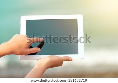 white tablet with a  blank empty screen in the hands 