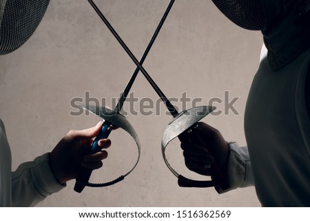 Fencer woman with fencing sword. Fencers duel start concept. Royalty-Free Stock Photo #1516362569
