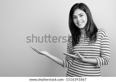 Young beautiful Indian woman against gray background