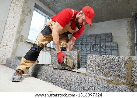 bricklayer working with ceramsite concrete blocks. Walling Royalty-Free Stock Photo #1516397324