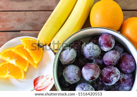 fruits for breakfast, bananas, oranges, plums
