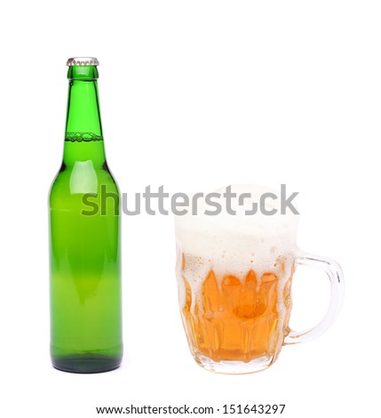 Closed bottle and mug of beer with froth.