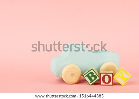 Pink background with colored cubes with letters Boy and toy car