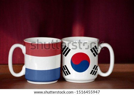 South Korea and Netherlands flag on two cups with blurry background