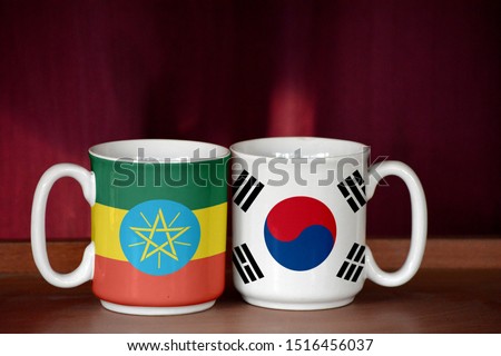 South Korea and Ethiopia flag on two cups with blurry background