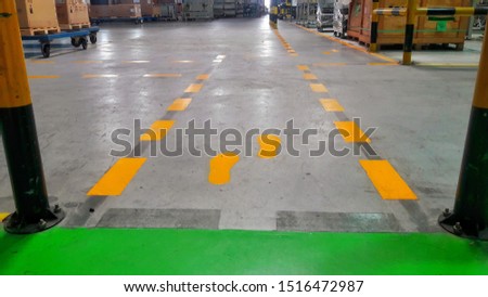 Walkway signs and footsteps are painted yellow on floor in the factory.