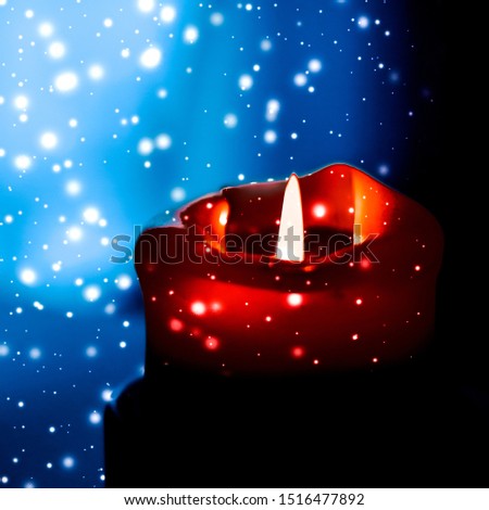 Happy holidays, greeting card and winter season concept - Red holiday candle on dark sparkling snowing background, luxury branding design for Christmas, New Years Eve and Valentines Day