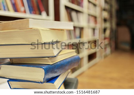 Stack of books on table in library
