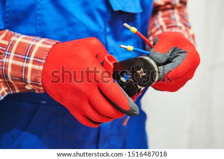electrician work with cable. crimping pliers in use Royalty-Free Stock Photo #1516487018