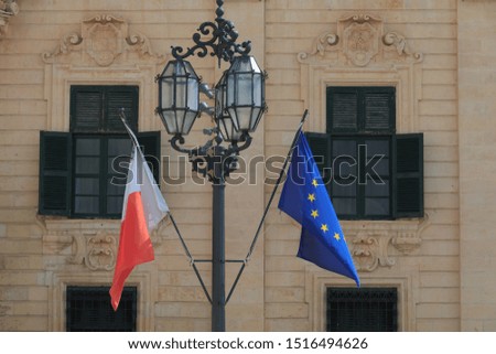 Malta national flag Europe union flag hang in front of old historic building in Valletta Malta