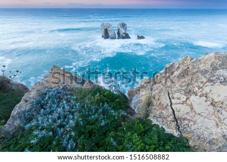 Sunset view from los urros at spain, north atlantic coastline. Beautiful and quite landscape fine art picture showing long exposure of a rock formation in the sea.