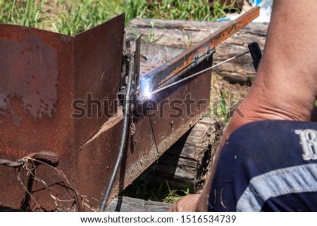 Welding metal at home. Worker with welding equipment. Metalworking.