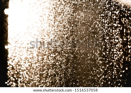 Moisty wet window with water running down the surface. Window glass after heavy rain lit by the setting sun. Abstract blurred background, Selective soft focus