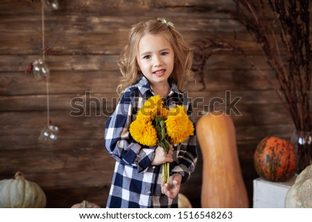 portrait of cute little girl with bouquet of yellow flowers, autumn background
