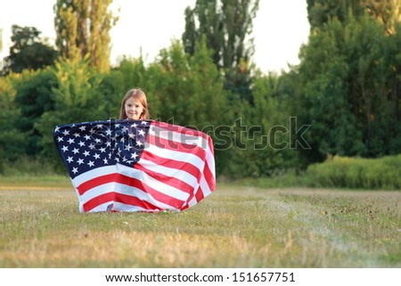 Happy adorable little girl smiling and waving American flag 