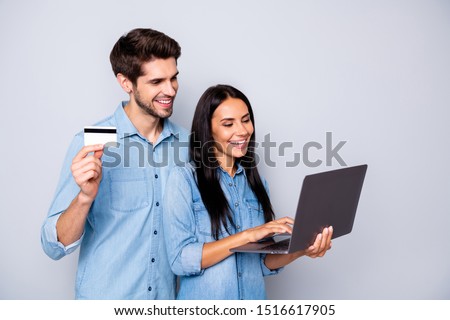 Photo of cheerful trendy charming business couple of two people together working on project holding credit card laptop isolated over grey color background