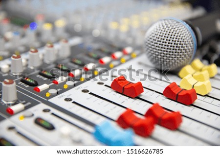 Close-up volume slide of sound mixer and microphone background in the studio for recording, editing, and Sound system control concept.