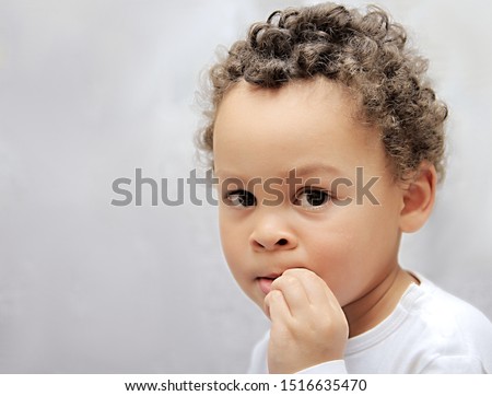 child biting his finger nails and sucking thumb stock photo