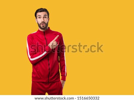 Young fitness man pointing to the side
