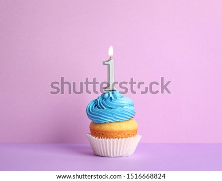 Birthday cupcake with number one candle on violet background Royalty-Free Stock Photo #1516668824
