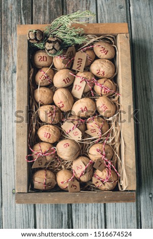 christmas, advent calendar, walnuts lie in a box, cones, gray wooden background