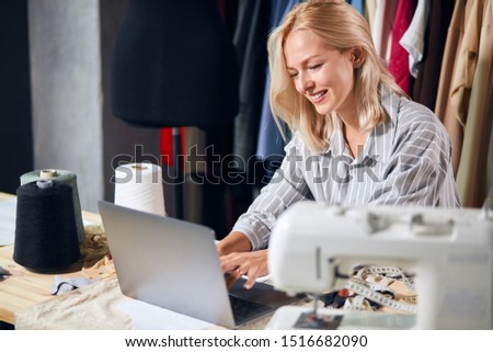 smiling positive tailor chatting with her boyfriend online, tailor giving recommendations, consulting clients online . close up photo. freelancer