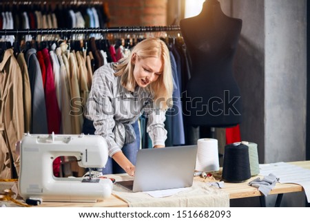 blonde tailor has problems with computer. close up photo