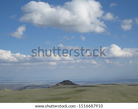 The picture was taken in the inaccessible area of Mongun - Taiga of the Republic of Tuva. High in the mountains, distant mountains appear blue, and clouds are located close to the ground.