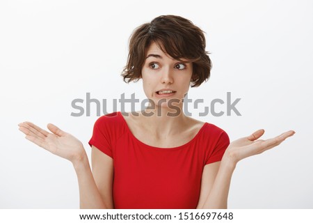 Yikes how embarrassing sorry. Awkward cute silly attractive woman short haircut grimacing perplexed unsure have doubts shrugging hands spread sideways unaware puzzled answer stand white background Royalty-Free Stock Photo #1516697648