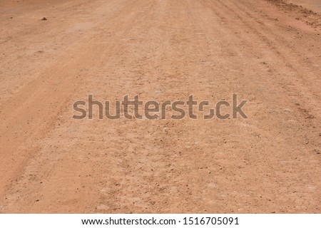 Red mud dry soil road pavement low angle view background texture