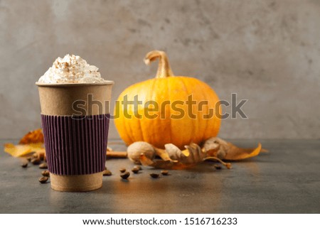 Paper cup with tasty pumpkin spice latte on grey table. Space for text
