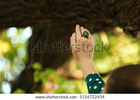Young woman wearing beautiful silver ring with opal gemstone outdoors, closeup