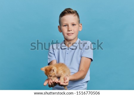 little boy giving a present to his friend on his birthday, here you are. celebration, gift. close up portrait, isolated blue background