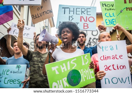 Group of activists is protesting outdoors - Crowd demonstrating against global warming and plastic pollution, concepts about green ecology and environmental sustainability