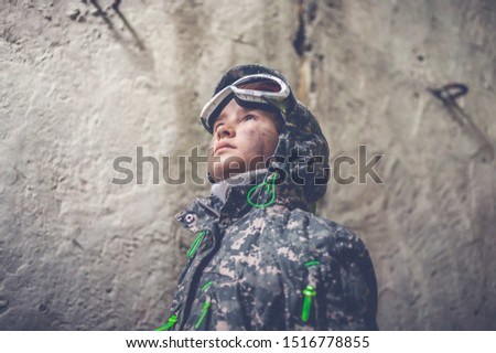 Serious girl in military uniform looking up. Disappointed and upset teenager girl. Disillusioned stalker in abandoned building. Girl with tired facial expression. Young stalker concept