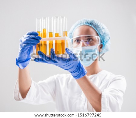 Scientist pouring organic oil. Beauty and cosmetics sciences. Laboratory equipment. White background