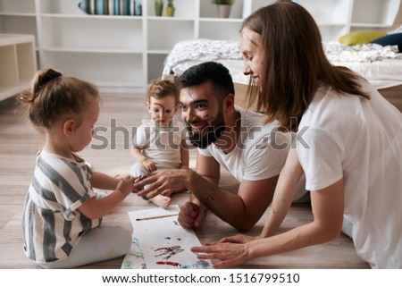 little cute girl getting manicure for bearded laughing father at home. close up photo