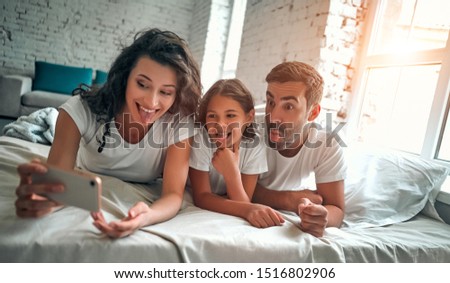 Happy young family take a self portrait with smart phone.