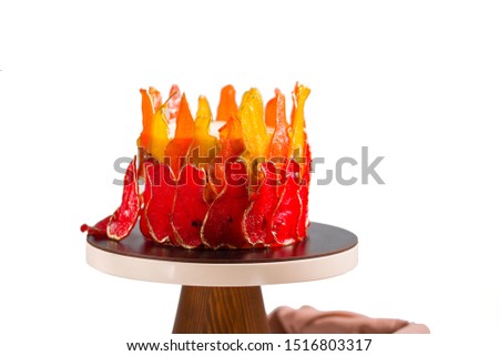 Beautiful and delicious dessert. The cake on the stand is decorated with red and yellow pears. Isolated on the white backgraund.