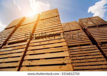 Wooden boxes stacked on each other. Outdoors. Blue sky background. Industrial