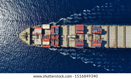 Aerial top down photo of large cargo container ship cruising the deep blue Mediterranean sea