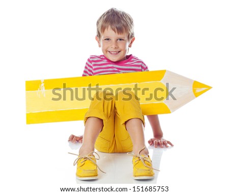 Cute little schoolboy with a pencil and looking at camera