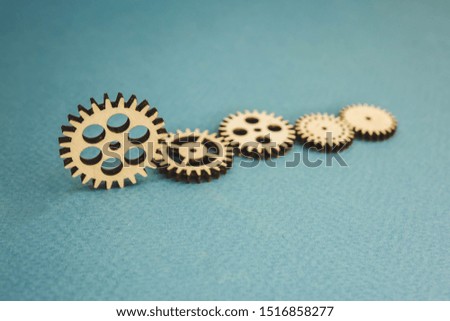 five wooden gears standing on a blue background