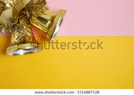 Golden bells on whatman paper in soft colors pink and yellow. Flat lay, Copy space.
