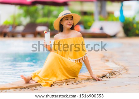 Portrait beautiful young asian woman leisure relax smile and happy with coconut juice around swimming pool in hotel resort for holiday vacation concept